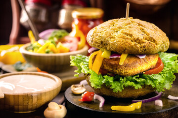 Vegan quinoa burgers with kale, lettuce, tomato, mushroom and tomato sauce on a rustic background. Plant-based food concept.