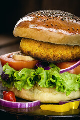 Vegan quinoa burgers with kale, lettuce, tomato, mushroom and tomato sauce on a rustic background. Plant-based food concept.