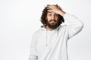 Yikes. Shocked young man slap forehead, looking troubled, forgot smth, panicking, standing in...
