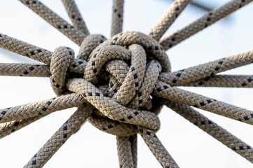 lots of ropes and a big knot against the blue sky