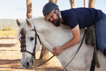 A rider hugging his horse's neck