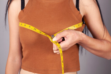 woman measuring her breast with a measuring tape
