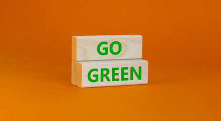 Time to go green ecology symbol. Concept words Go green on wooden blocks on a beautiful orange background. Business, ecology and go green concept. Copy space.