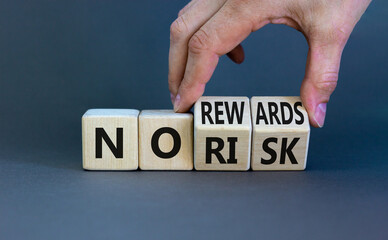 No risk or rewards symbol. Businessman turns wooden cubes and changes words 'no risk' to 'no...