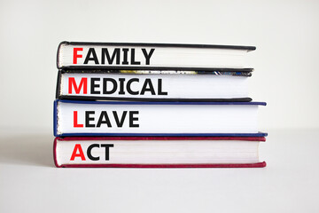 FMLA, family medical leave act symbol. Concept words 'FMLA, family medical leave act' on books on a beautiful white background. Copy space. Medical and FMLA, family medical leave act concept.