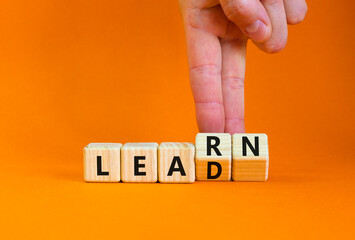 Learn and lead symbol. Businessman turns wooden cubes, changes the word 'learn' to 'lead'....