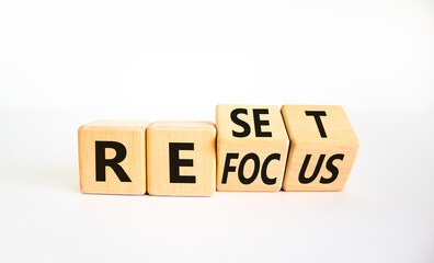 Refocus and reset symbol. Businessman turned cubes and changed the word 'refocus' to 'reset'. Beautiful white table, white background. Business refocus and reset concept. Copy space.