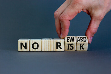 No risk and reward symbol. Businessman turns wooden cubes and changes words 'no risk' to 'no reward'. Beautiful grey background. No risk and reward, business concept. Copy space.