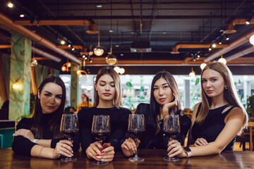 Girlfriends with glasses of wine at a meeting in a restaurant.