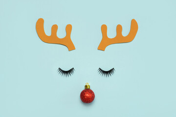 Merry Christmas. Christmas Rudolph reindeer horns with false eyelashes and red christmas ball over...