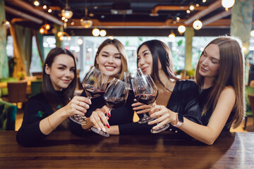 Girlfriends with glasses of wine at a meeting in a restaurant.