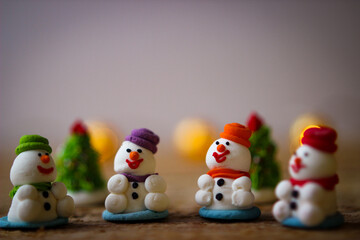 Christmas decor. A miniature figures of powdered sugar snowman with a colorful hat