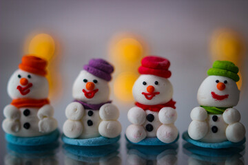Christmas decor. A miniature figures of powdered sugar snowman with a colorful hat