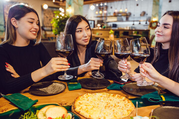Attractive girls drinking wine at a dinner in a restaurant.