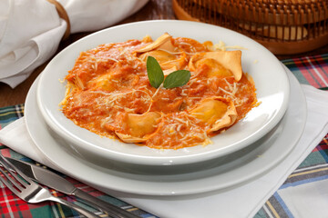 Ravioli, massa italiana, ao molho de tomate, queijo parmesão e folha de manjericão. - obrazy, fototapety, plakaty