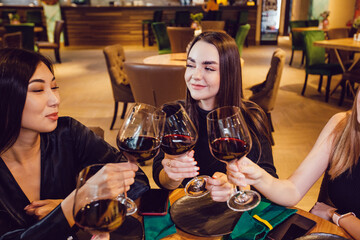 Attractive girls drinking wine at a dinner in a restaurant.