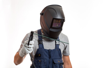 A man in a welding mask, robotic clothes and gloves, holding a wire with a welding electrode.