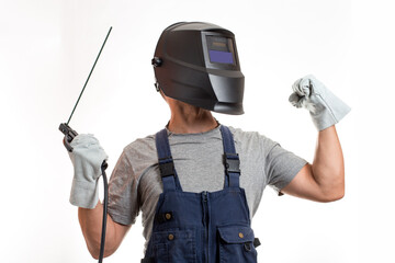 A man in a welding mask, robotic clothes and gloves, holding a wire with a welding electrode.