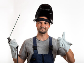 A man with a welding mask on his head, raised up, open face, holding welding wires and an electrode...