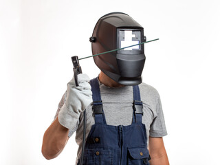 A man in a welding mask, robotic clothes and gloves, holding a wire with a welding electrode.