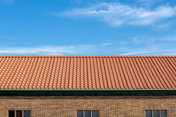 Orange brick rooftop under blue sky and white clouds, Tiles background details, Shingles texture, Abstract geometric pattern, Roof brick material and building wall.