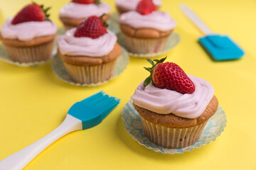 Natural strawberry cupcake and cream on yellow background
