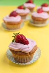Natural strawberry cupcake and cream on yellow background
