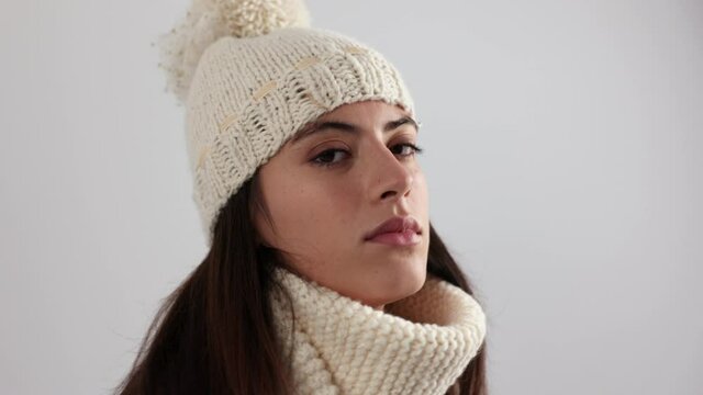 Woman posing and dancing in knitwear hat and scarf