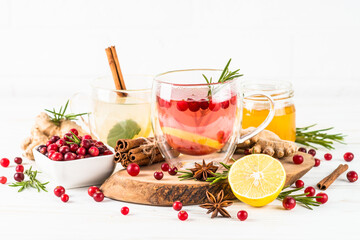 Cranberry tea and ginger tea with lemon and spices in glass mugs. Healthy hot vitamin drink.