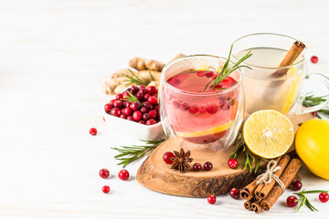 Cranberry tea with lemon and rosemary in glass mug. Healthy hot vitamin drink.