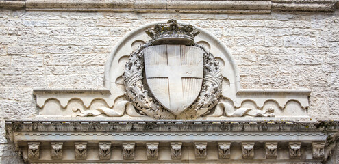 Statue of on the facade of the medieval sign in Italy. Monument of architecture on the streets of the city of Rome. Light wall background for copy space, travel to Europe