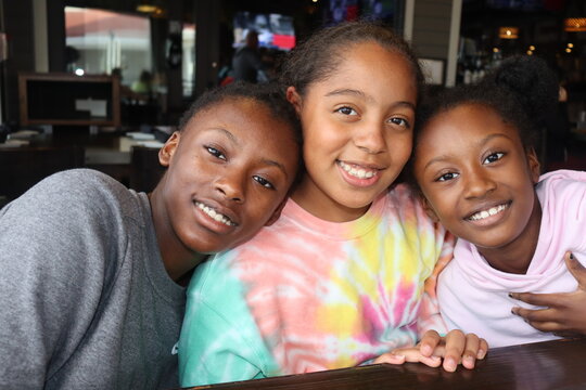 Three Black Girls smiling indoors close up