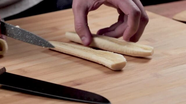 Krojenie banana na drobne kawałki. Przygotowanie sałatki owocowej.