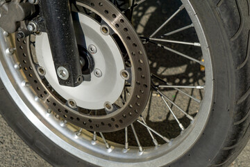 Motorcycle wheel close up. Wheel spokes. Wheel of an old motorcycle on the asphalt.