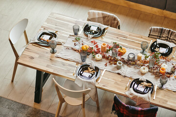 High angle view of wooden dining table serving with beautiful dishes decorated in autumn style