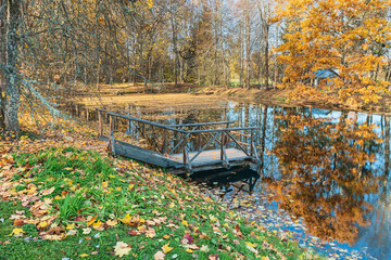 old wooden playground on the shore of a picturesque autumn pond in the Pushkin Hills, Pskov, Russia