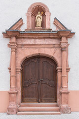 old church wooden door with ornaments in the historic part of the small German town of Tauberbischofsheim