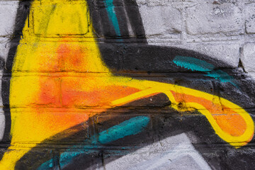 Paint splash on old brick wall close-up, graffiti detail, colorful background