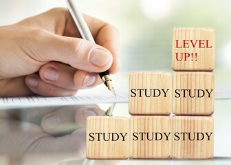 Wooden blocks with study and level up. Studying person
