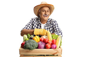 Mature farmer leaning on a crate full of fresh healthy vegetabales