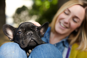 Closeup on happy young woman with French Bulldog outdoors in autumn