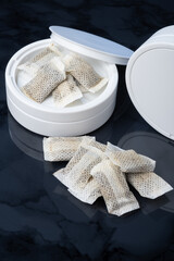 Closeup of a white swedish snus can and portion snuff pouches.