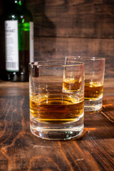 Glasses of strong scotch single malt whisky served on dark wooden table in old pub