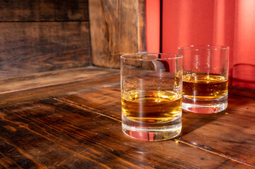 Glasses of strong scotch single malt whisky served on dark wooden table in old pub