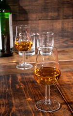 Glasses of strong scotch single malt whisky served on dark wooden table in old pub