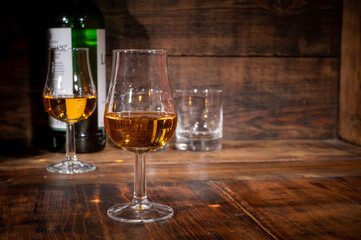 Glasses of strong scotch single malt whisky served on dark wooden table in old pub
