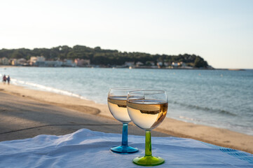 Summer time in Provence, drinking of cold gris rose wine on sandy beach and blue sea near Toulon, Var department, France