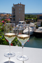 Summer on French Riviera Cote d'Azur, drinking cold dry white wine from Cotes de Provence on outdoor terrase in Port Grimaud, Var, France