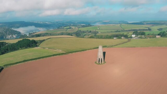 Aerial view of a 19th Century limestone tower The Daymark in a meadow on the coast in Kingswear, Devon, UK