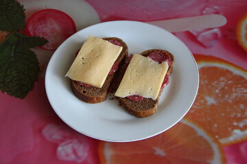 Two black bread sandwiches with salami and cheese